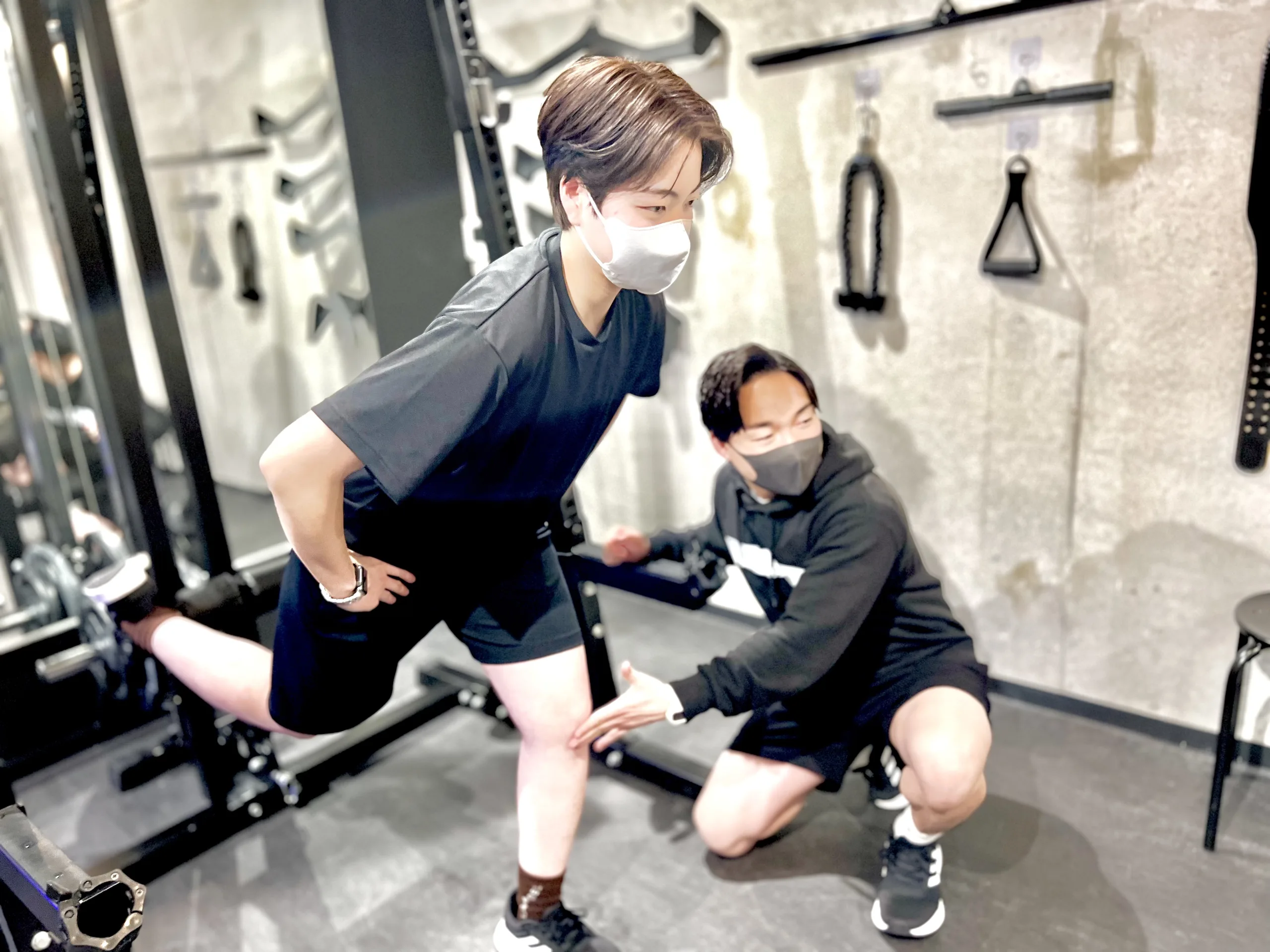 LYRIM表参道・外苑前店で男性トレーナーにトレーニング指導を受けている日本人女性