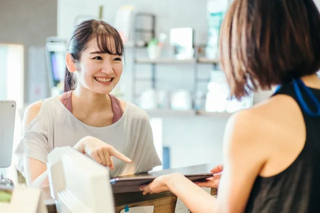 ジムのトレーナーと楽しそうに会話している人