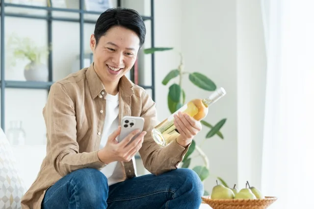 お酒とスマホを見て勉強している人
