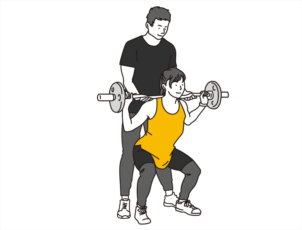 スクワットする女性と男性トレーナー