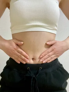 お腹に手を充てる女性