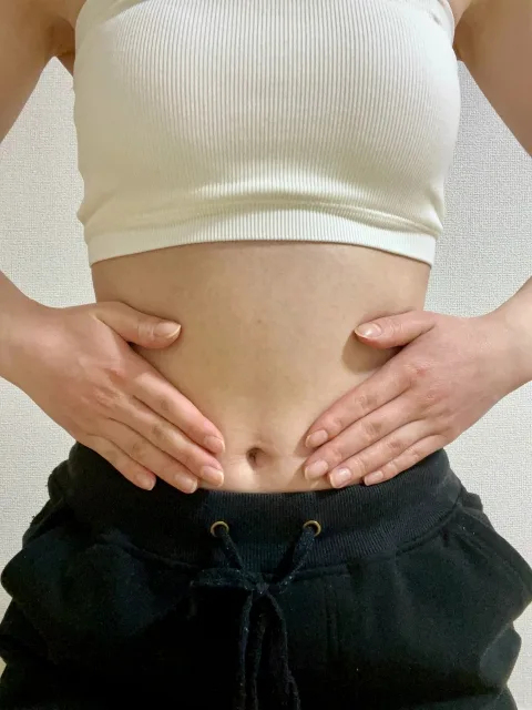 お腹に手を充てる女性